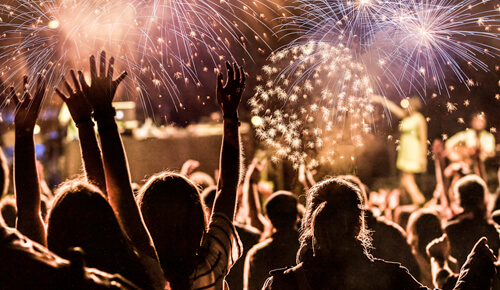 Pessoas vestindo branco comemorando ano novo, com vista para fogos de artificios a noite!